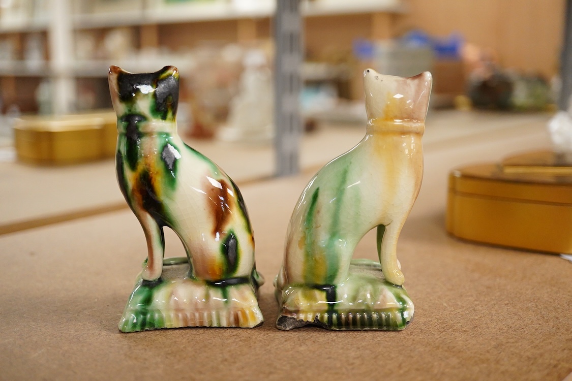 A pair of tortoiseshell glazed pottery figures of cats, early 19th century, 19cm high
